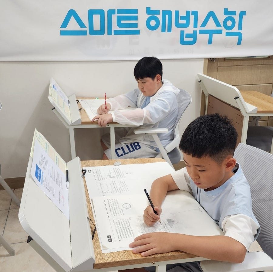 해법플러스에듀학원 교실에서 시험지를 푸는 학생들